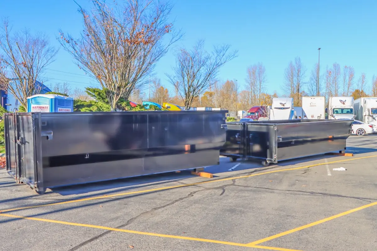 Professional dumpster rental service with roll-off container on residential driveway in Forks